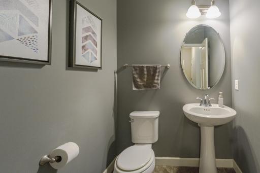 The half bathroom white trim and a 3-panel door.