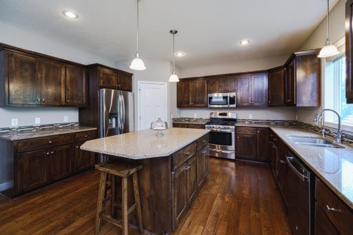 The kitchen has an oversized island, with quartz counters and pendant lighting.