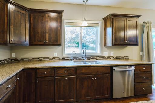 A tile backsplash dresses up this space, which has updated stainless appliances including a gas range, new dishwasher and disposal in 2024, and a new drinking water system in 2022. The sink is a gooseneck style.