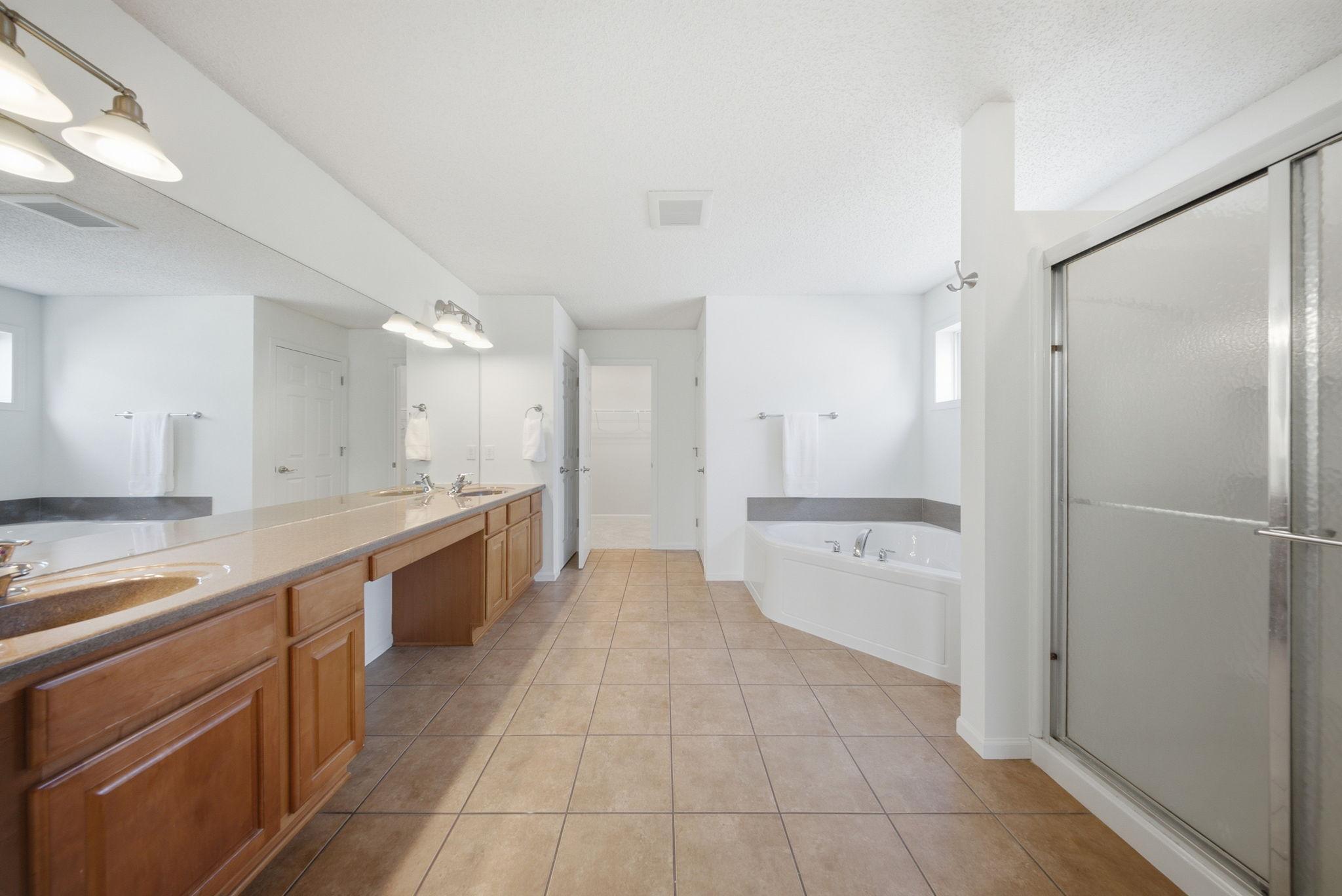 Primary full bathroom with access to the walk in closet. Complete with separate tub and shower.