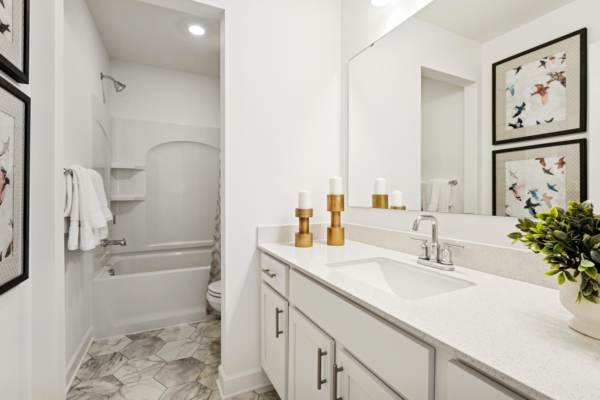 (Photo is of a decorated model, actual homes finishes will vary) Located on the upper level, this secondary bath provides more than enough space! The vanity space has a nice separation from the toilet & shower.