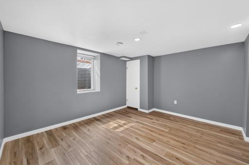A spacious lower-level bedroom with updated flooring