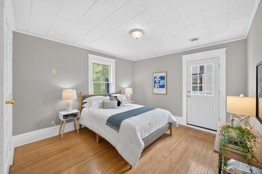 The bright upper-level primary bedroom has direct balcony access