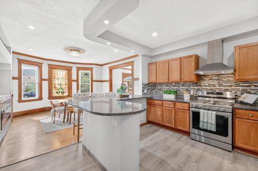 The remodeled 2024 kitchen opens to an expansive peninsula with seating