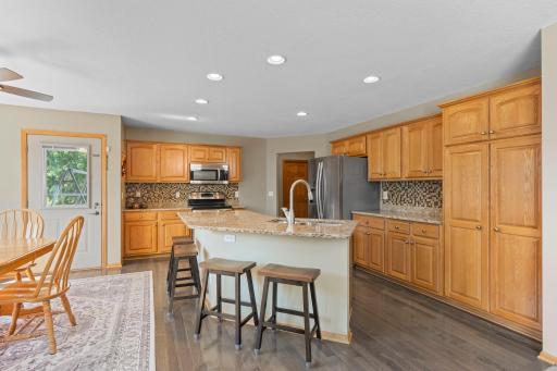 The thoughtfully designed kitchen is a chef's dream, offering granite countertops, a center island, abundant cabinetry, and an informal dining area with picturesque views of the deck and backyard, ideal for everyday living and entertaining.