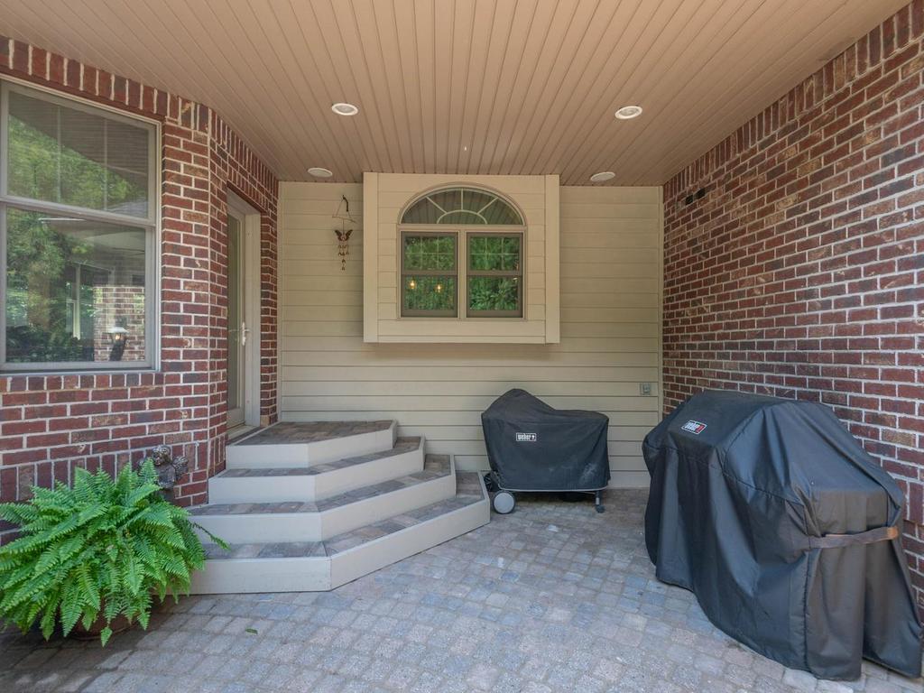 Covered grilling area provides a sheltered transition from the formal dining room to the expansive paver patio and outdoor entertaining spaces.