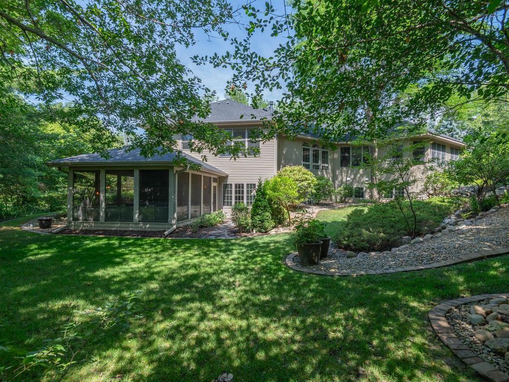 Private screened porch is tucked away underneath the shade of the mature trees.