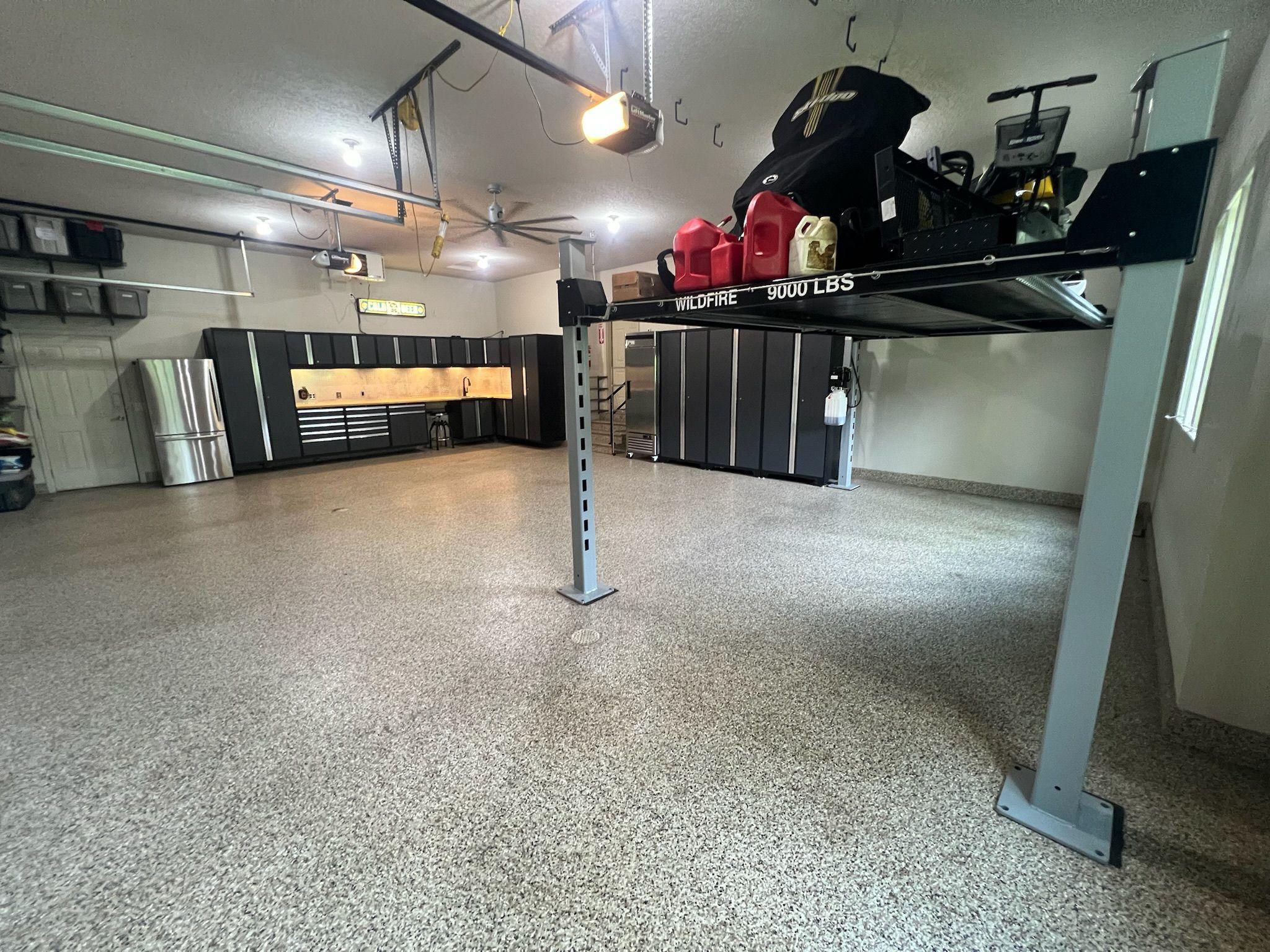 The heated/insulated 3-stall Garage has epoxy floor, floor drains to holding tank, built-in cabinets/workbench, built-in shelving & Lg ceiling fan for great climate control! Vehicle hoist, fridge, freezer & rolling chrome tool cabinet are excluded.