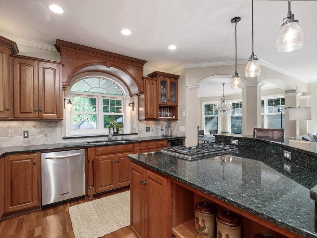 Arched window above the sink overlooking the beautiful side patio.