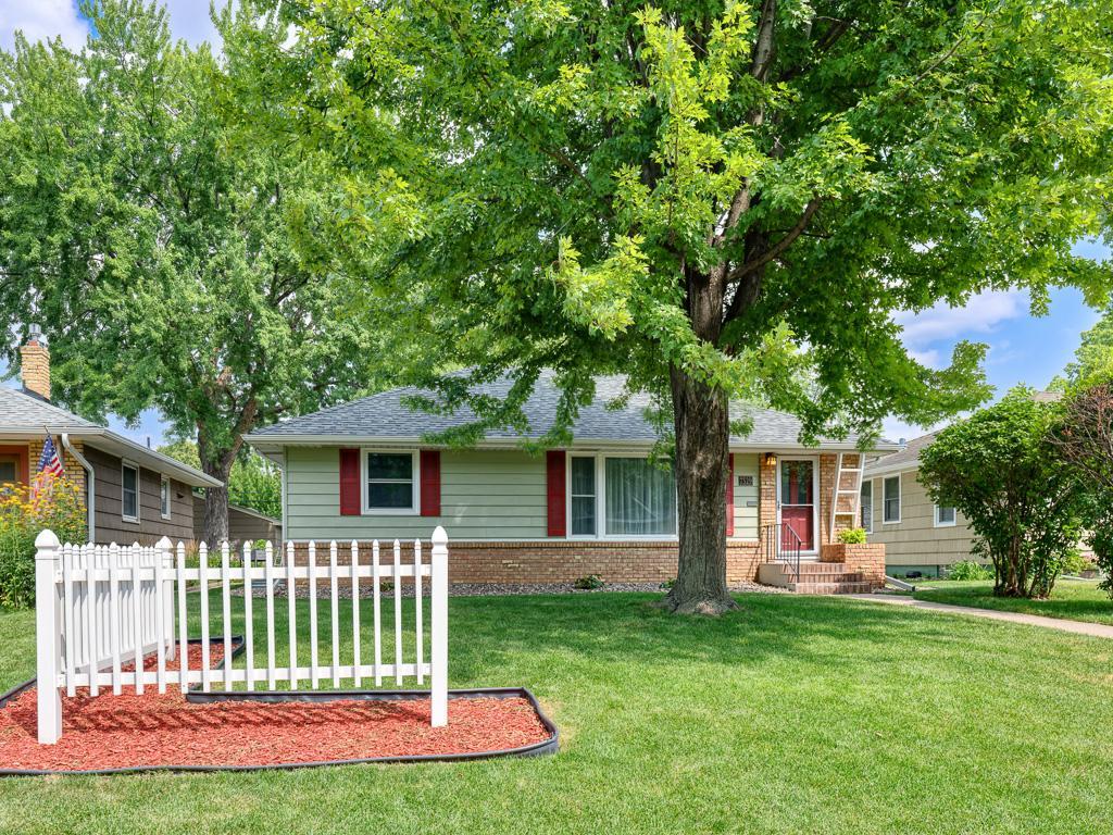 Charming curb appeal with nice touches and a shady tree.