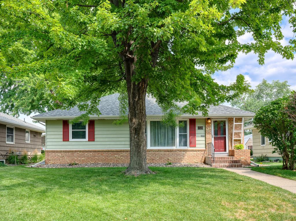Charming curb appeal with nice touches and a shady tree.
