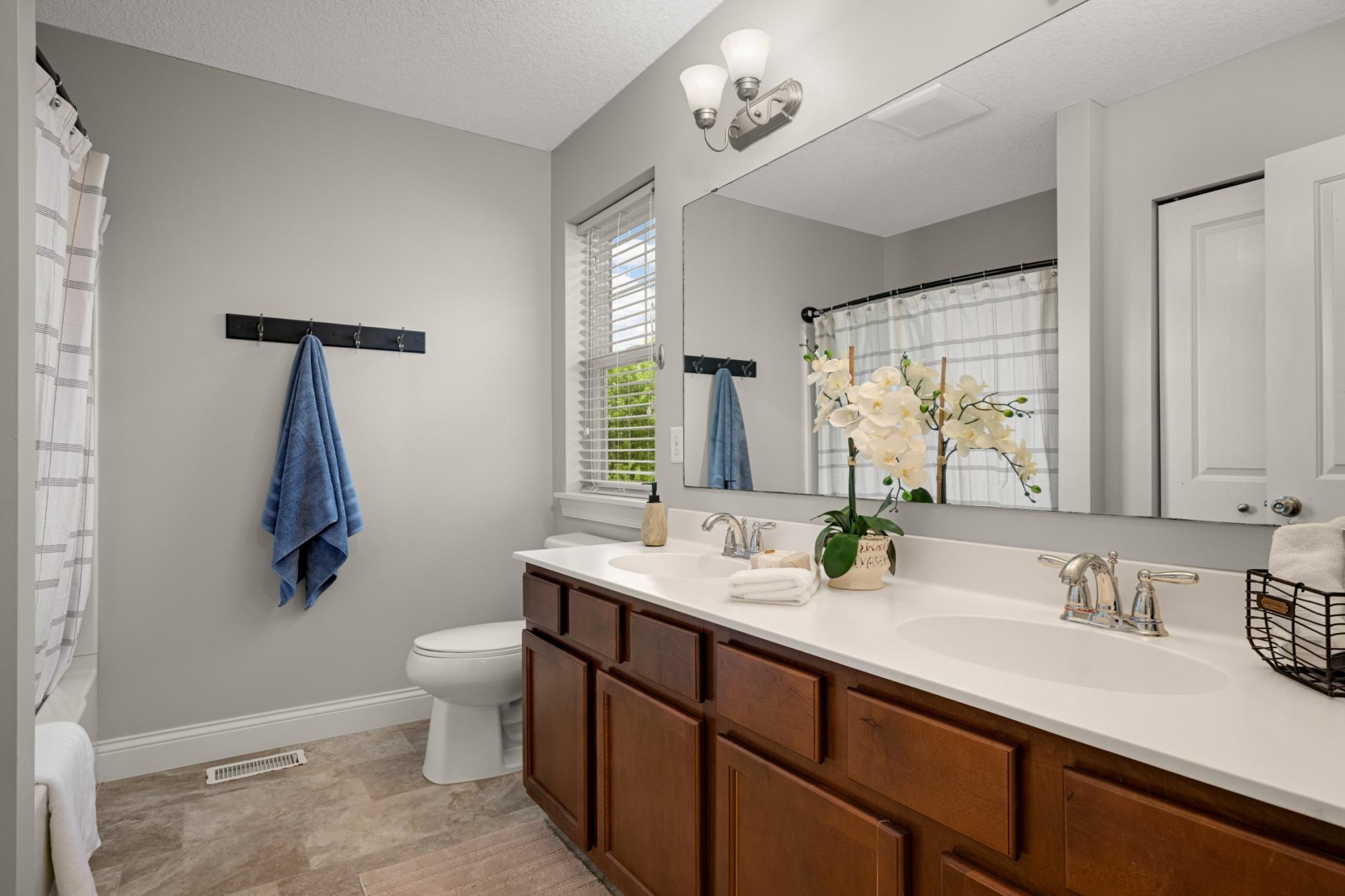 Upper level full bathroom with double sink vanity.