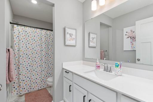 There is a bright full bath off the hallway. The large vanity offers plenty of storage space.