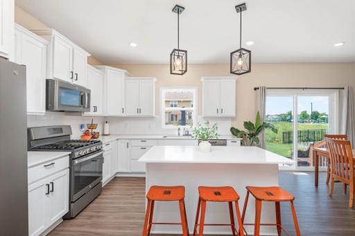 The all white kitchen has tons of thoughtfully designed cabinet and drawer space. The durable LVP flooring has a nice gray and tan color contrast.