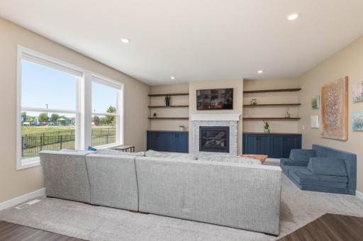 Family room offers a gas fireplace with mantle and stone surround. The homeowners added beautiful and very useful cabinetry and shelving on either side of the fireplace!