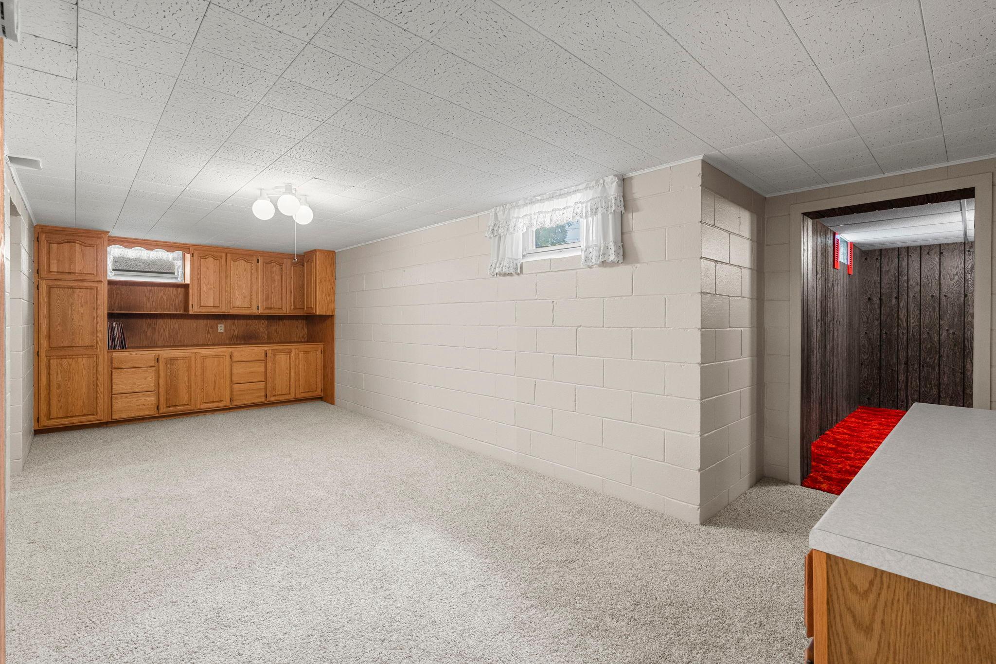 Nearby, the recreation room adds built-in cabinetry and countertop space.