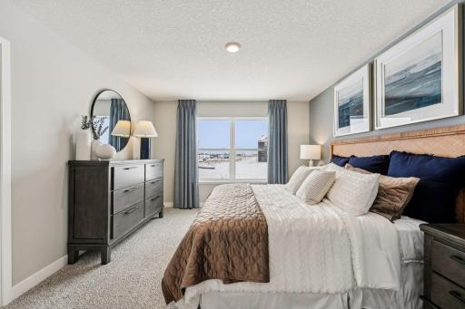 Beautiful primary bedroom upstairs with private ensuite bathroom and walk-in closet. Photo of model home, color & options will vary.