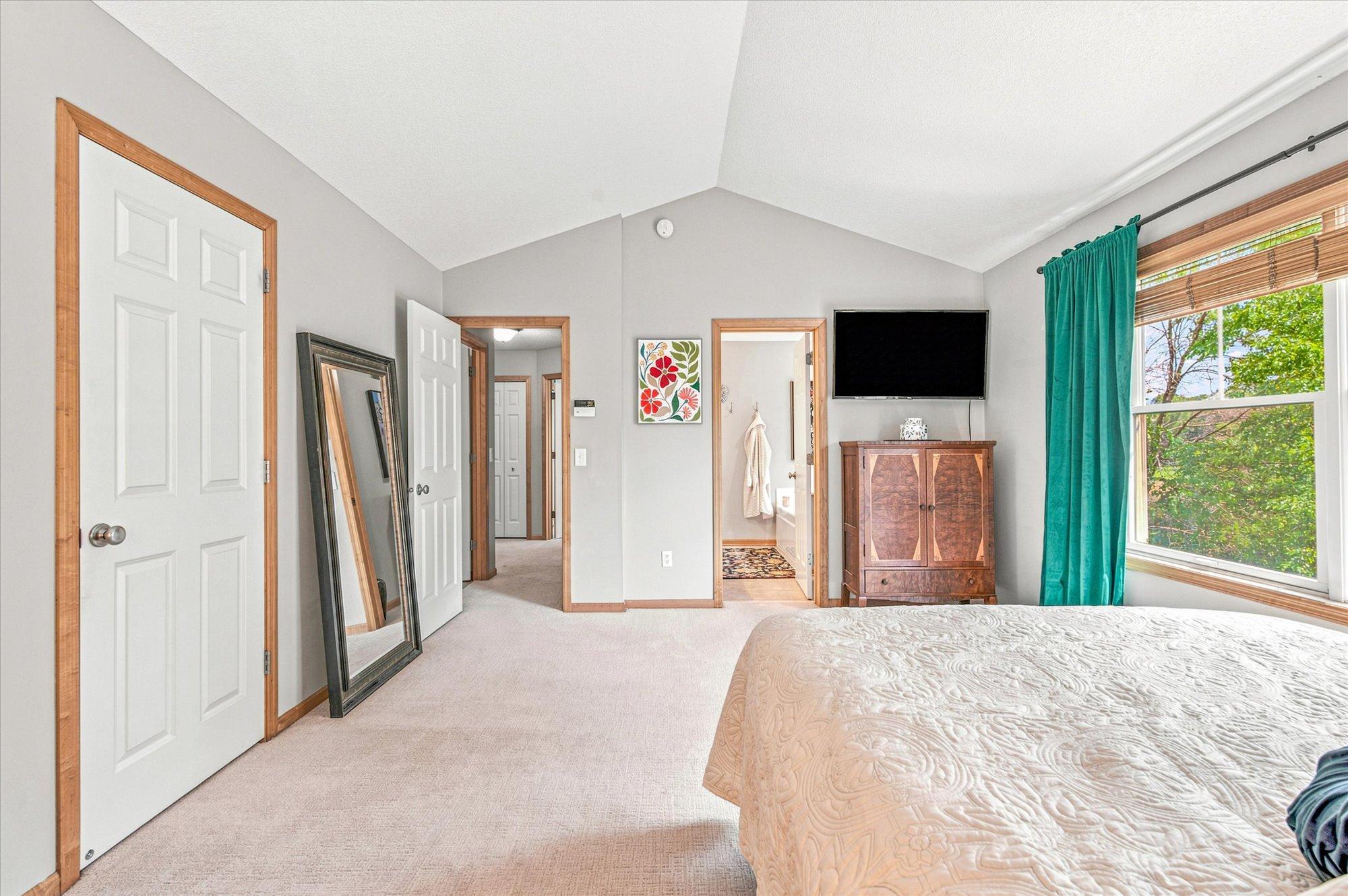 Another view of the primary bedroom shows the private bath and proximity to the other bedrooms on the upper level.