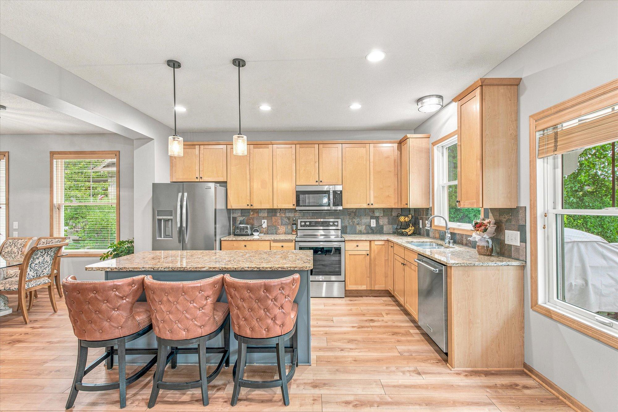 The bright and open kitchen features a large island with built-in storage and seating for casual meals.