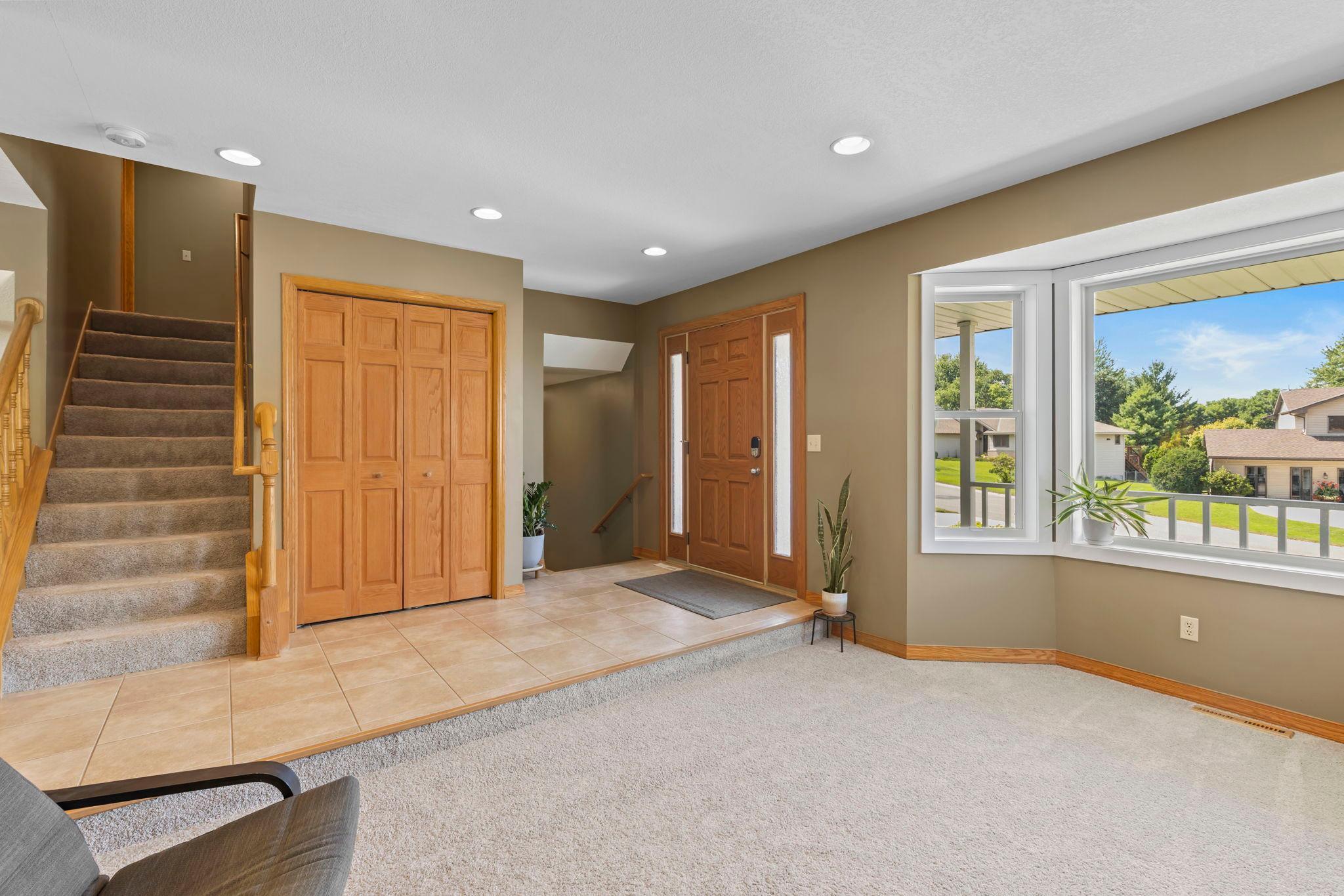 The front living room is bright and welcoming, with a bay window that fills the space with natural light and creates a cozy place to relax.