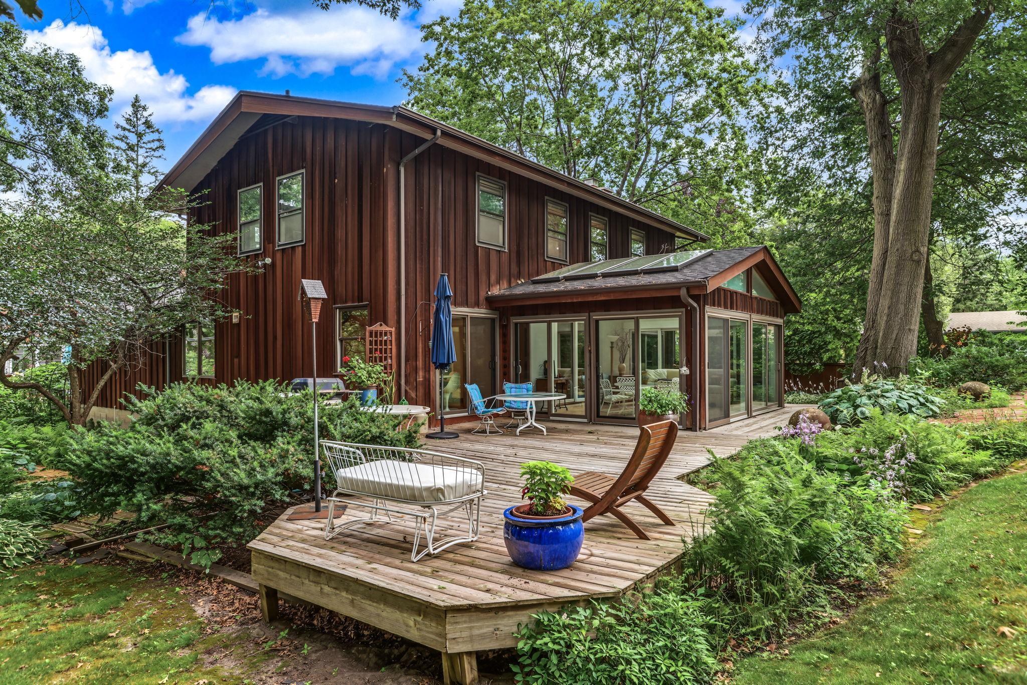 The home features Redwood siding, a sunroom and large deck overlooking the beautifully landscaped double lot.