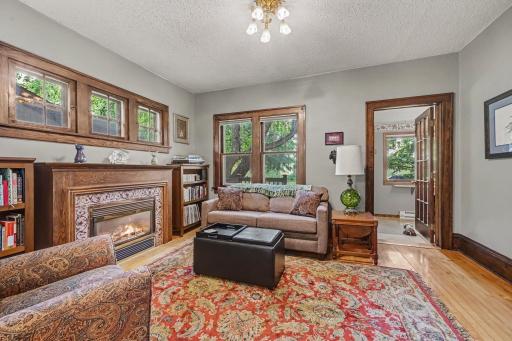 Stunning woodwork and vintage charm! Lovely french door from sunroom to living room. Gorgeous gas fireplace topped with beautiful piano windows!