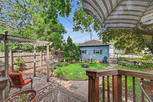 Wonderful backyard space with deck, pergola covered patio, firepit, edged with perennials.