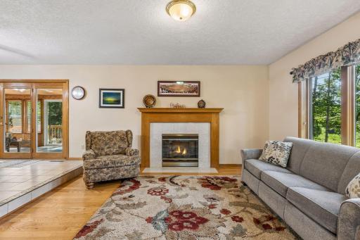 Open-concept living room with a gas-burning fireplace and classic hardwood floors.