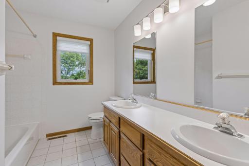 Full bathroom with dual vanities with new mirrors and lighting