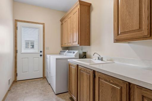 Main level laundry room with service door and large utility sink
