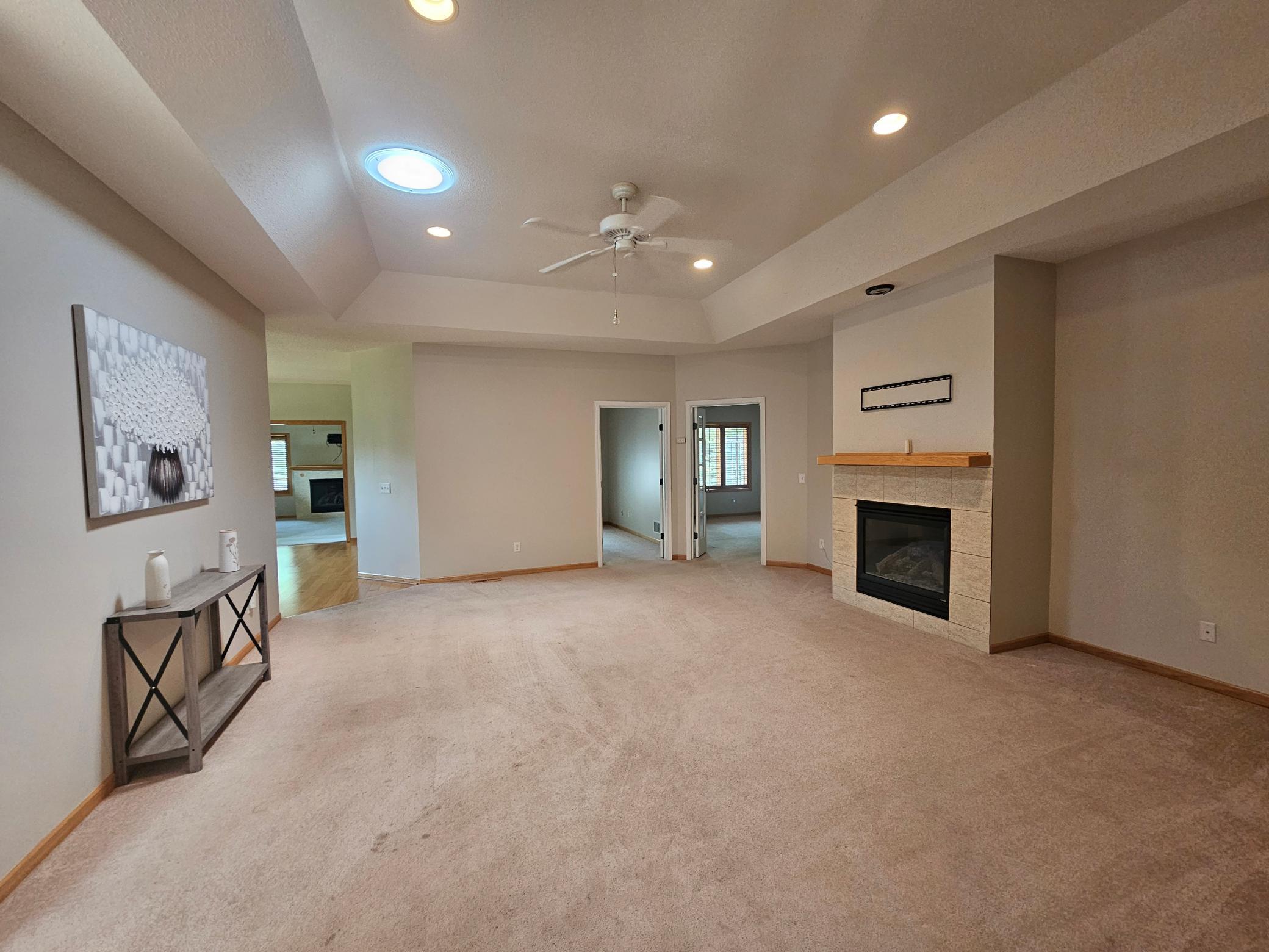 Large Living room with natural light, gas fireplace and ceiling fan on beautiful detailed ceiling.