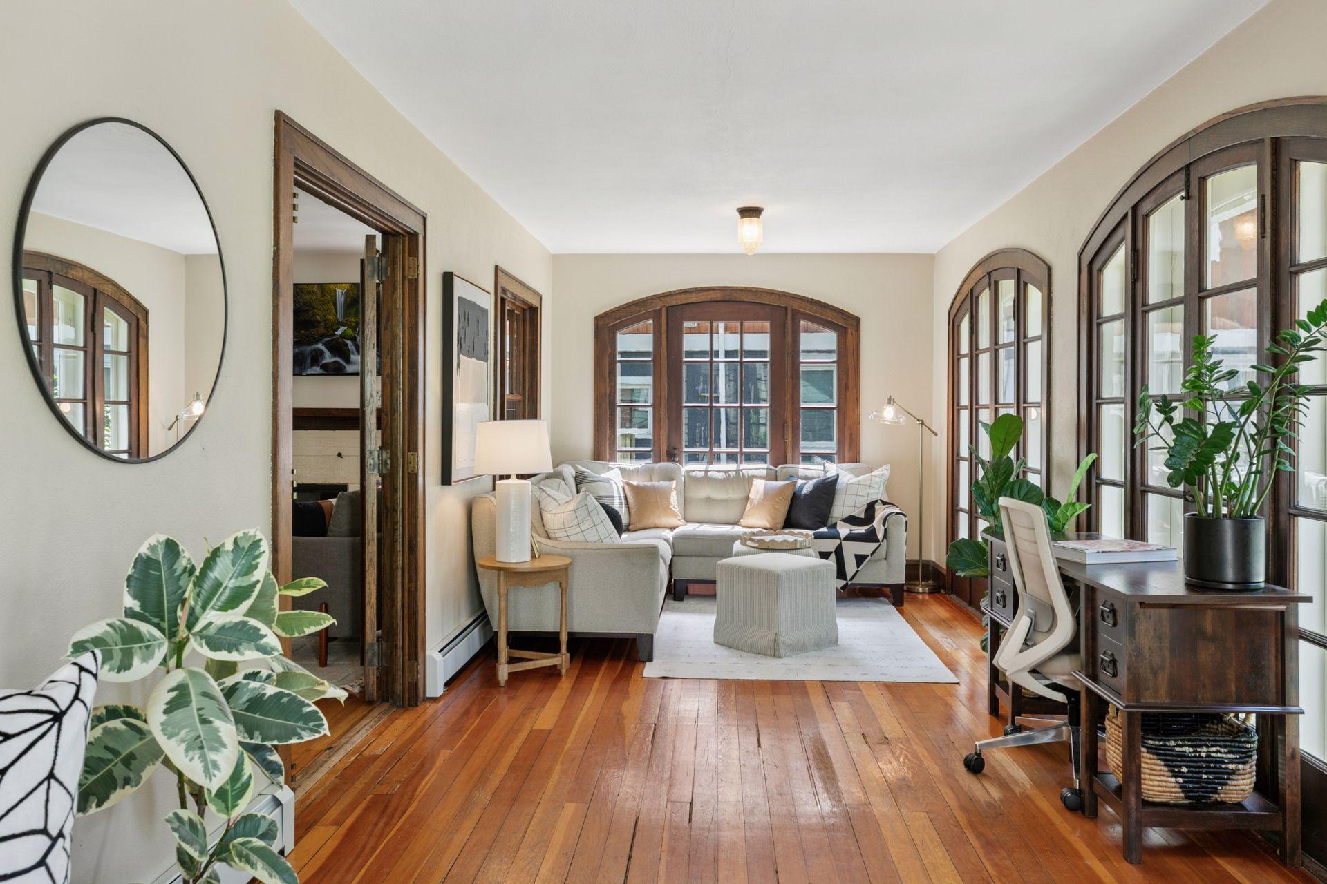 Inviting sun room with walls of light and hardwood floors