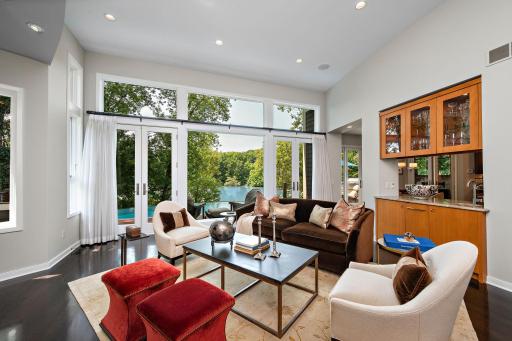 Elegant custom sapele hardwood built-ins elevate the main level living room, pairing glass front display cabinetry and generous storage with a sophisticated serving area - perfectly suited for effortless everyday living and entertaining.