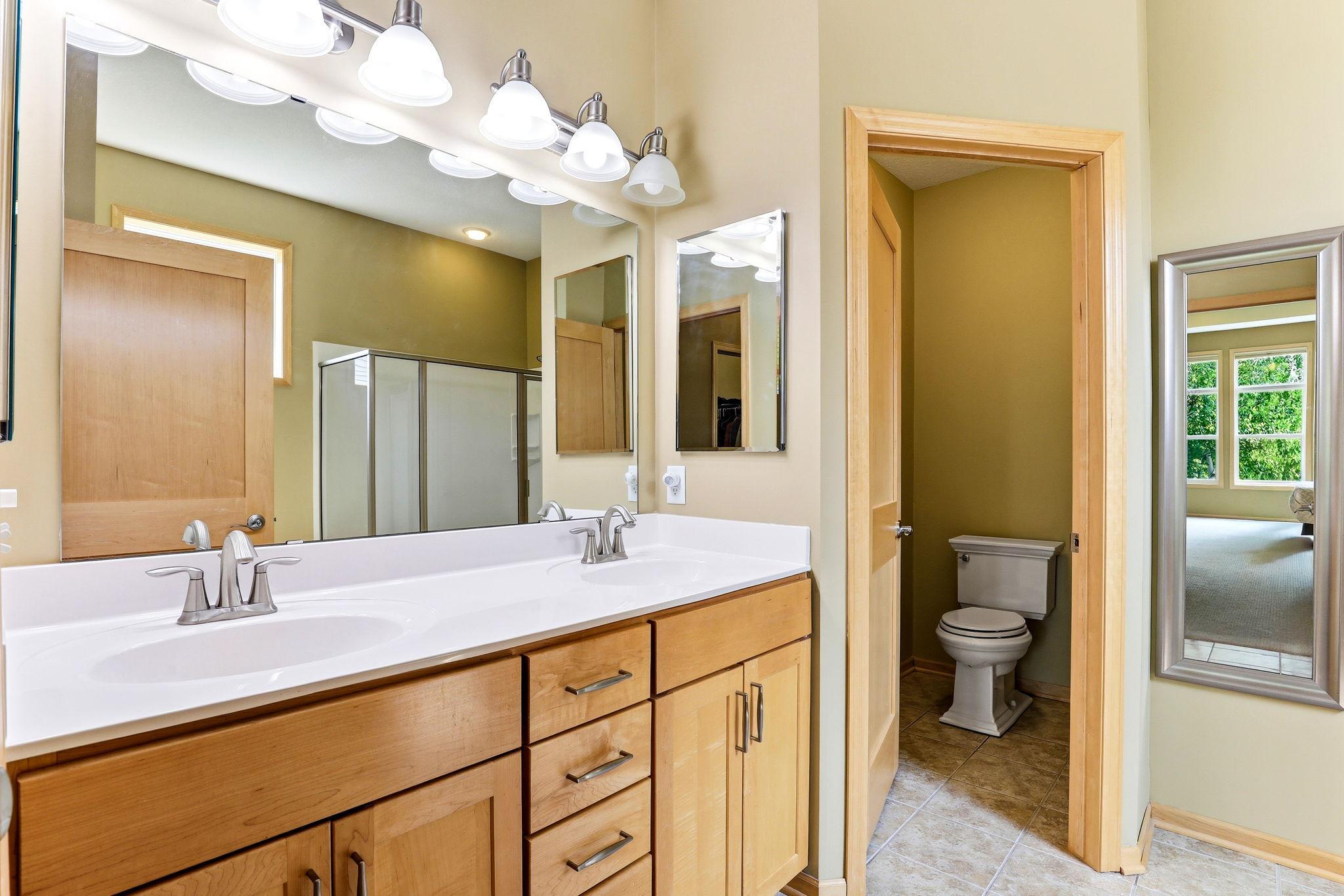 Ensuite features double sinks, a spacious shower, and a private toilet area for a polished, spa-like experience.