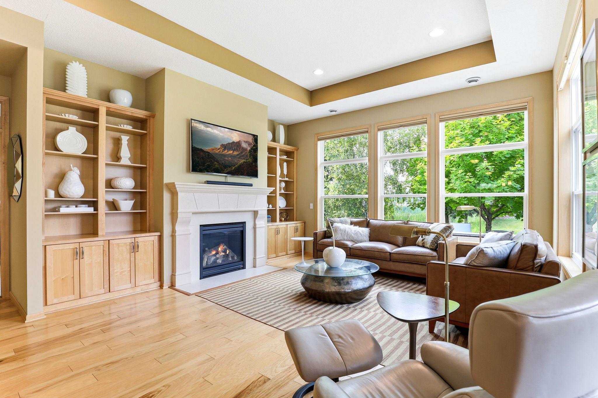 Living room centered around a glowing gas fireplace with custom built-ins for a polished, upscale focal point.