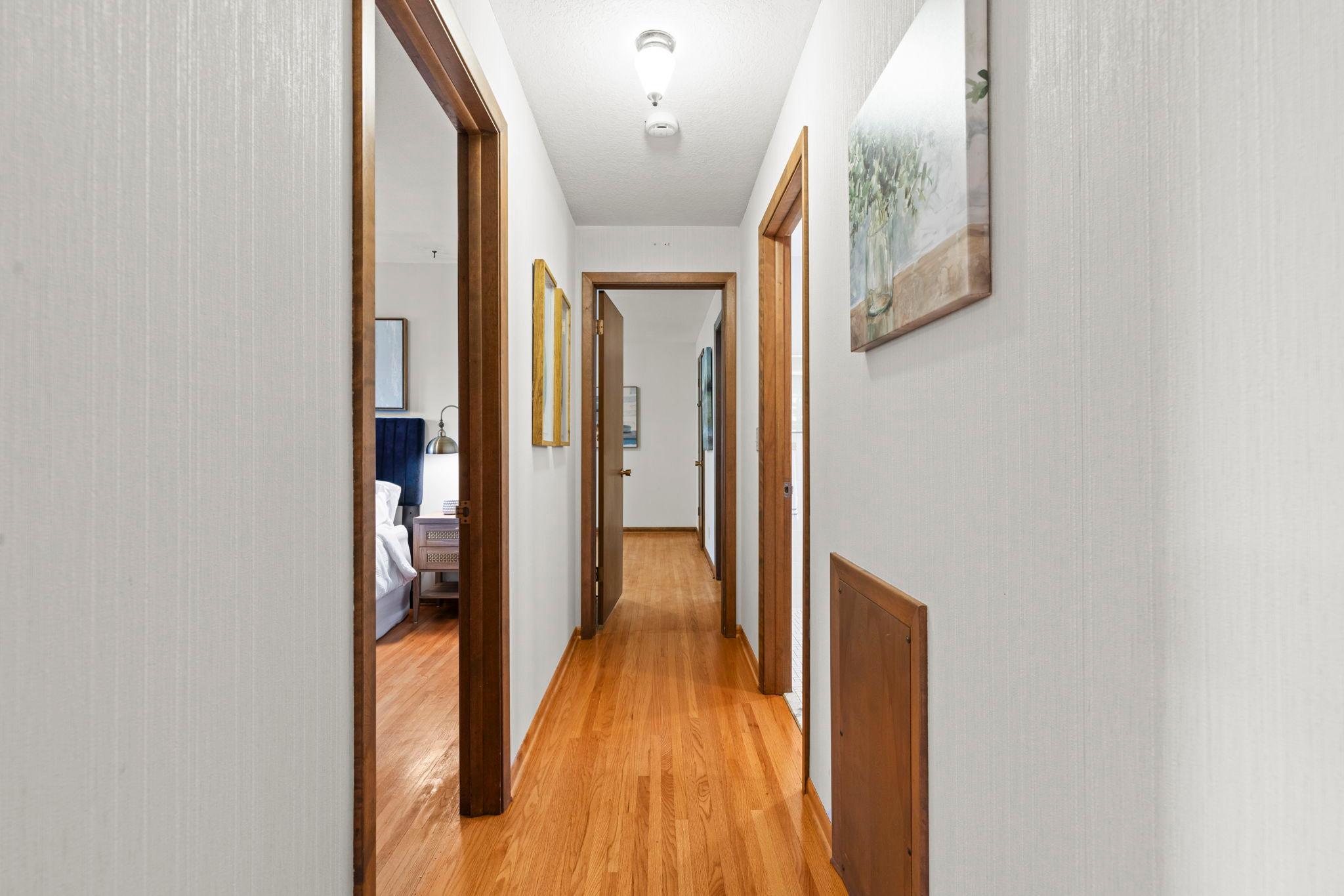 Main floor hallway leads the way to two bedrooms and two bathrooms