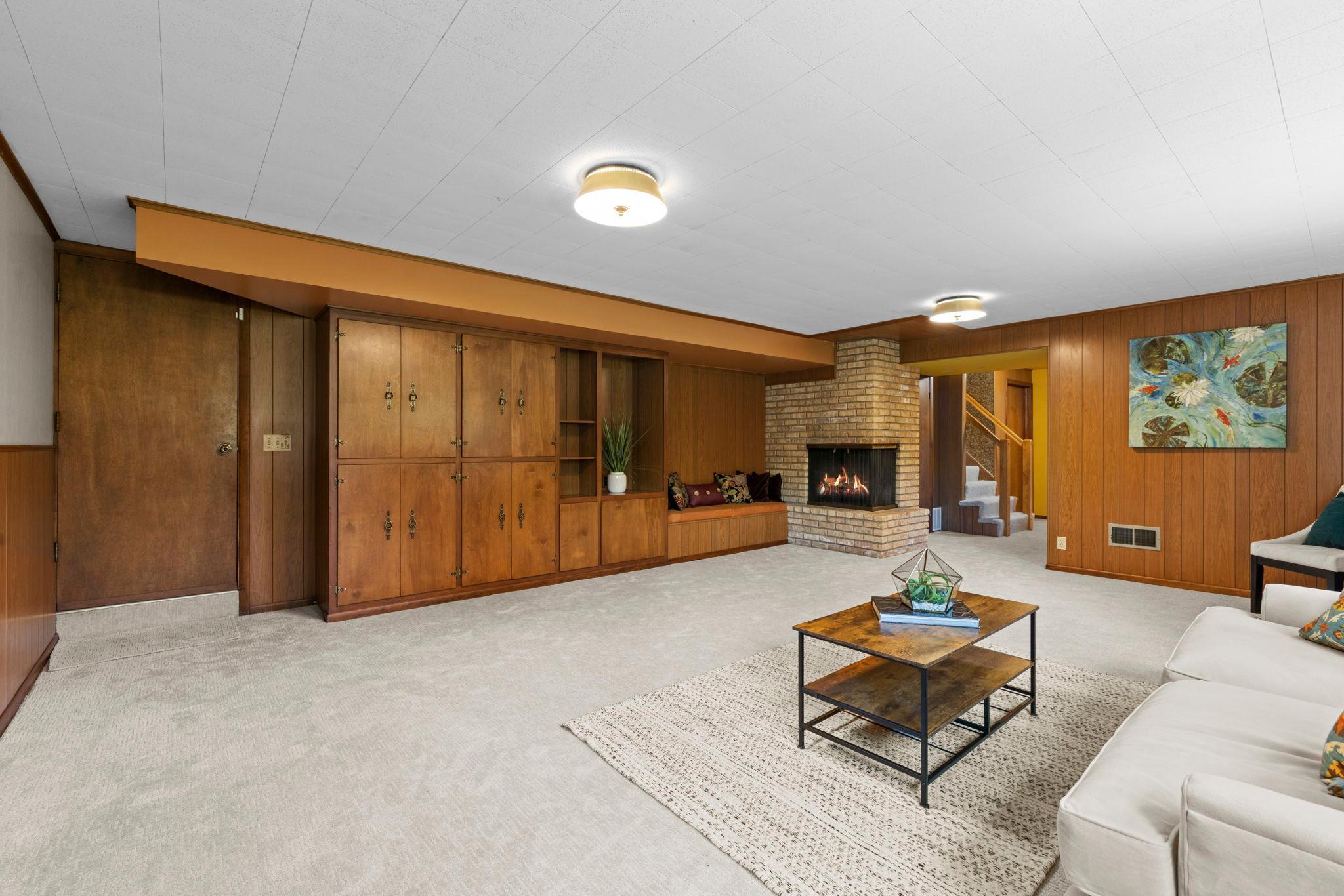 Lower level family room with decorative fireplace and builtins