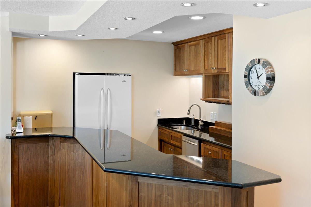wet bar with custom cabinetry and grantie countertops and slate floors too