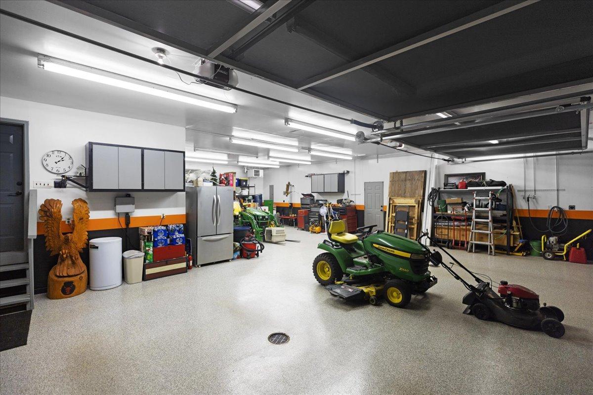 large light fixtures and retractable screens line the ceilings of 6-car garage.