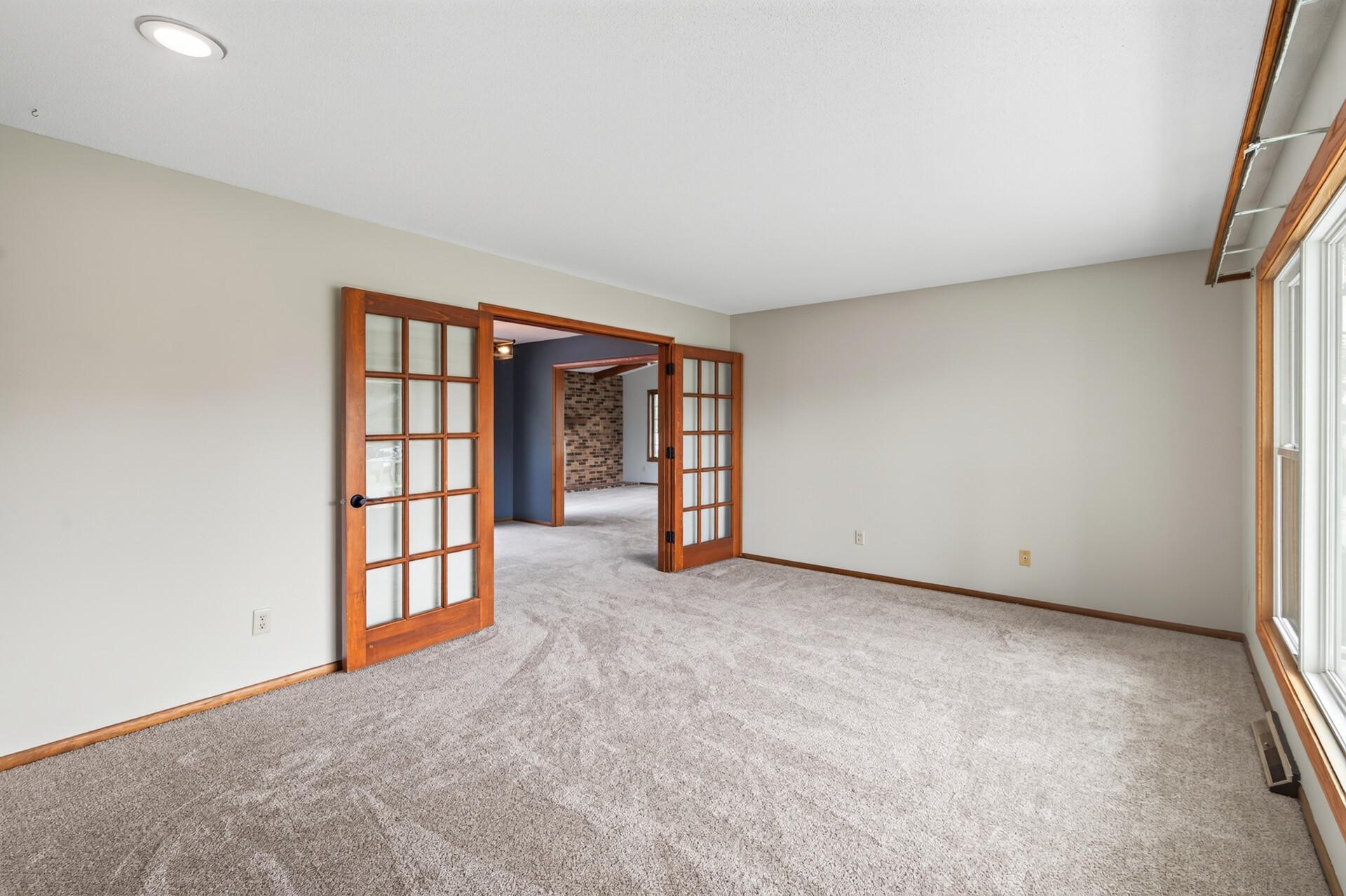 Main level living room with new carpeting and french doors leading to the family room and formal dining room!