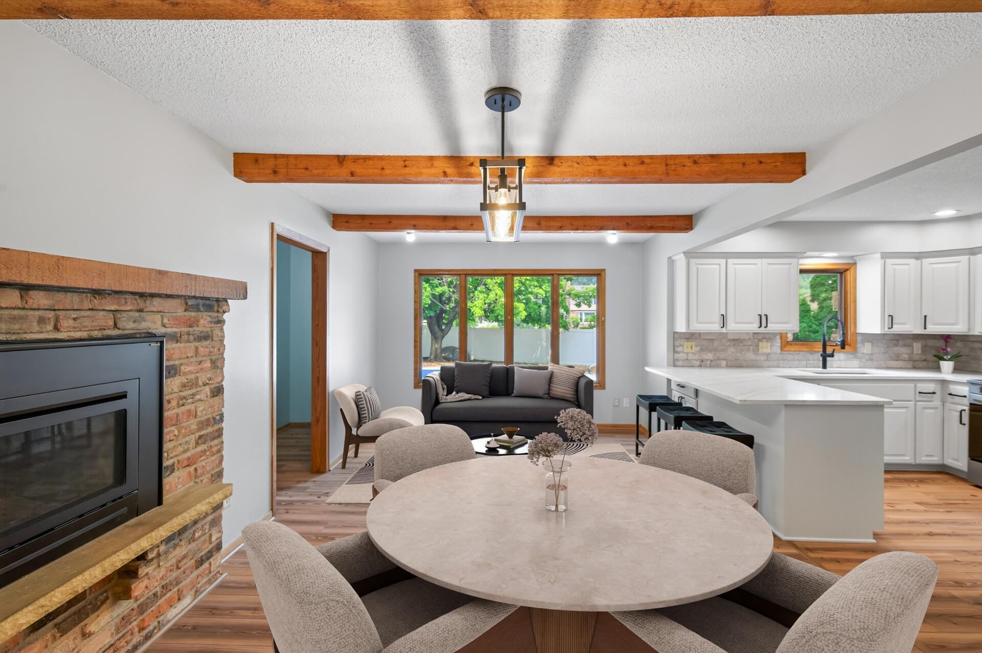 Informal dining room/den with a cozy gas fireplace and new plank flooring (virtual furniture).