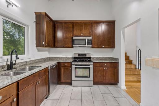 Granite and stainless kitchen with tile flooring.
