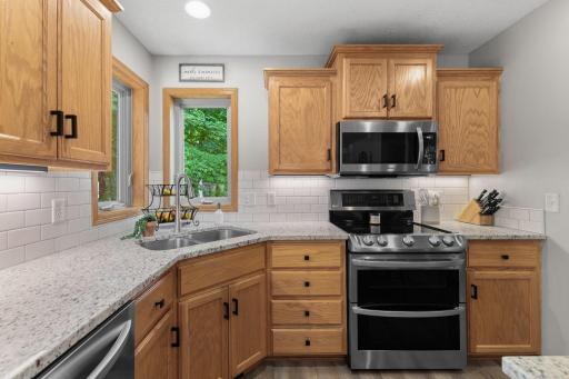 Inviting kitchen with new lighting and large corner windows that overlook the private backyard