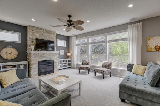 Gather in the spacious great room showcasing a beautiful stone fireplace and oversized windows that flood the home with natural light!
