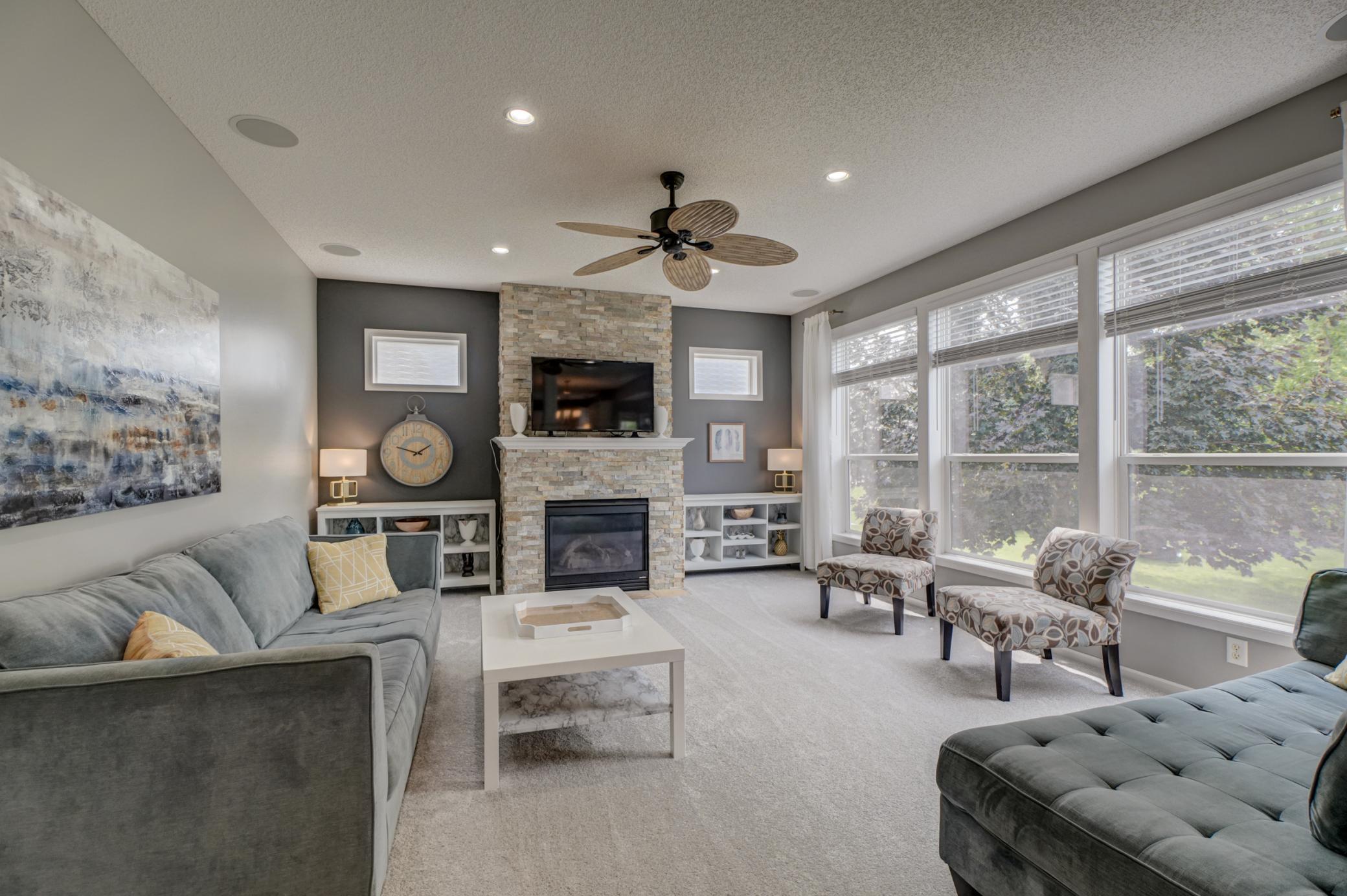 Relax by the impressive stone-surround fireplace while oversized windows showcase beautiful natural light throughout the room!