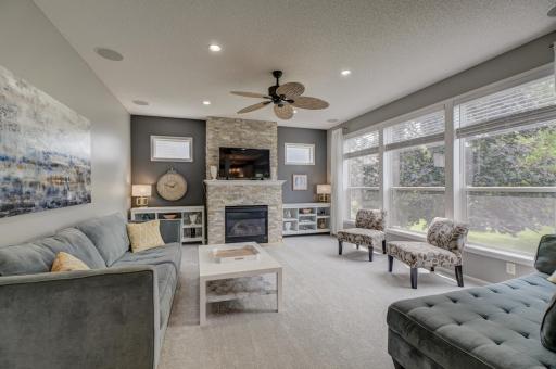 Relax by the impressive stone-surround fireplace while oversized windows showcase beautiful natural light throughout the room!