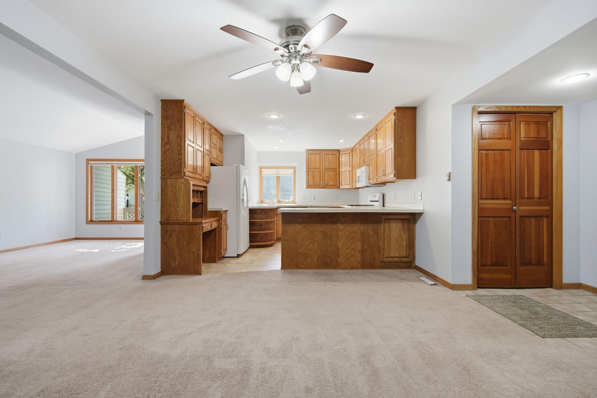 Abundant kitchen featuring generous cabinetry, ample counter space, a functional peninsula, and a window that fills the space with natural light.