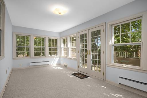 The four season porch is surrounded by walls of windows.