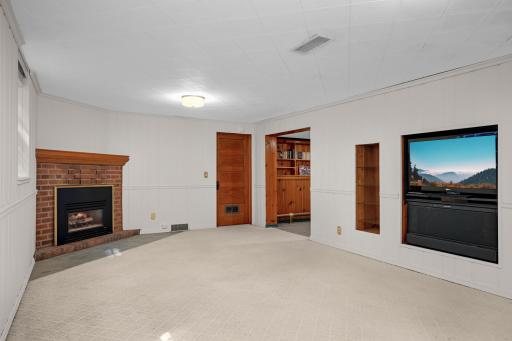 The lower level family room with cozy gas fireplace and large windows.