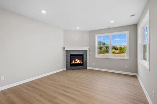 The Great Room is the heart of this home, where the family gathers to watch movies, enjoy leisurely weekend activities and laugh loudly together. The fireplace warms up the space.